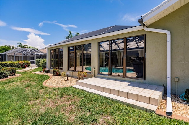 back of house featuring a lawn and glass enclosure