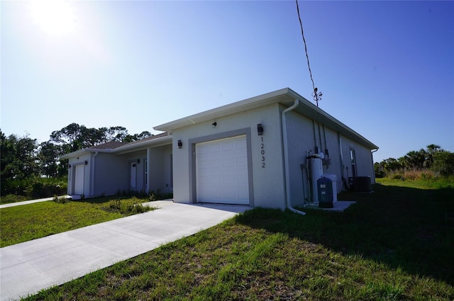 ranch-style house featuring a garage, a front yard, and central AC