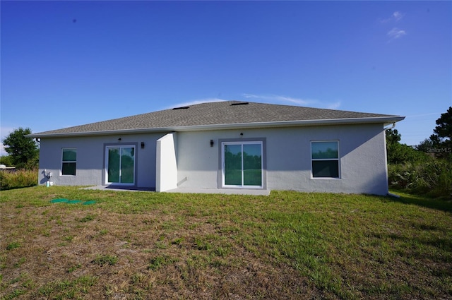 rear view of house featuring a yard