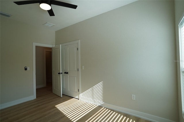 unfurnished bedroom featuring ceiling fan, hardwood / wood-style flooring, and a closet