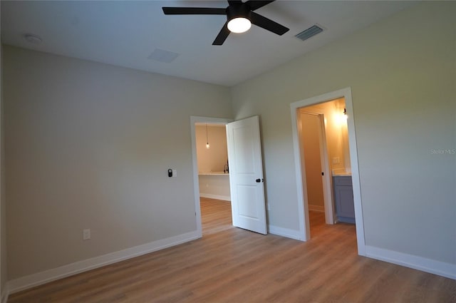 unfurnished bedroom featuring ceiling fan, light hardwood / wood-style floors, and ensuite bath