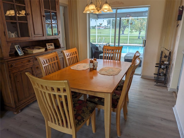 dining room with light hardwood / wood-style flooring and an inviting chandelier