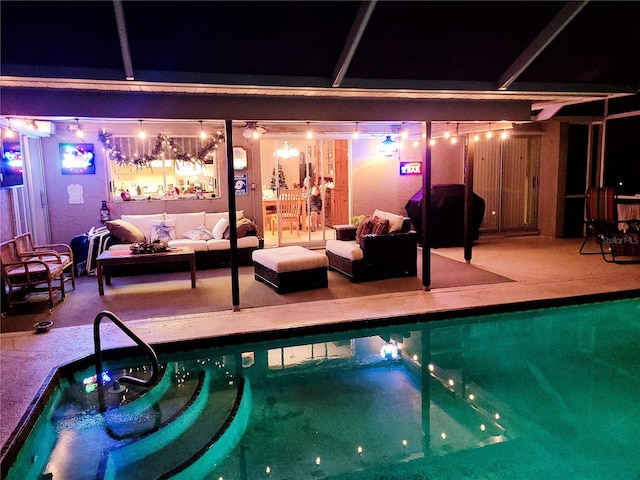 pool at night featuring area for grilling and a hot tub