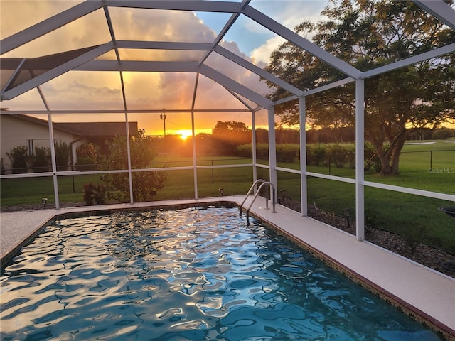 pool at dusk with glass enclosure and a yard