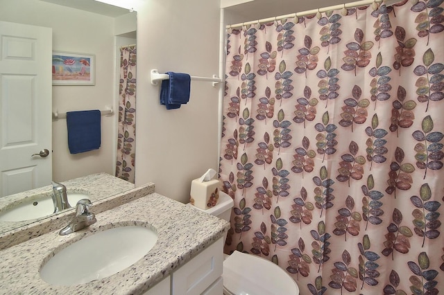 bathroom with vanity, curtained shower, and toilet