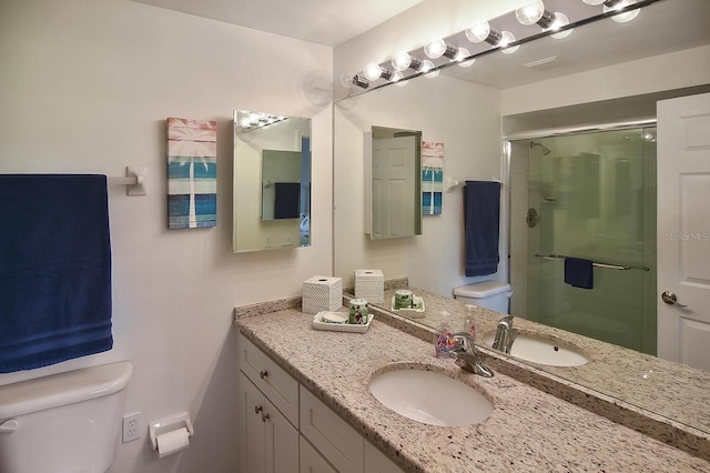 bathroom with vanity, toilet, and an enclosed shower