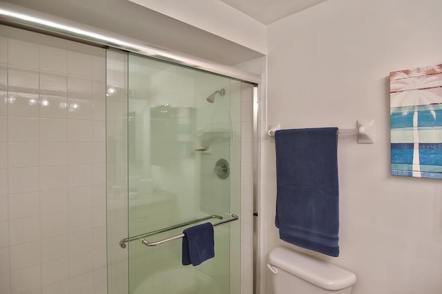 bathroom with toilet and an enclosed shower