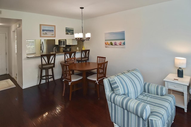 dining area featuring an inviting chandelier and dark wood-type flooring