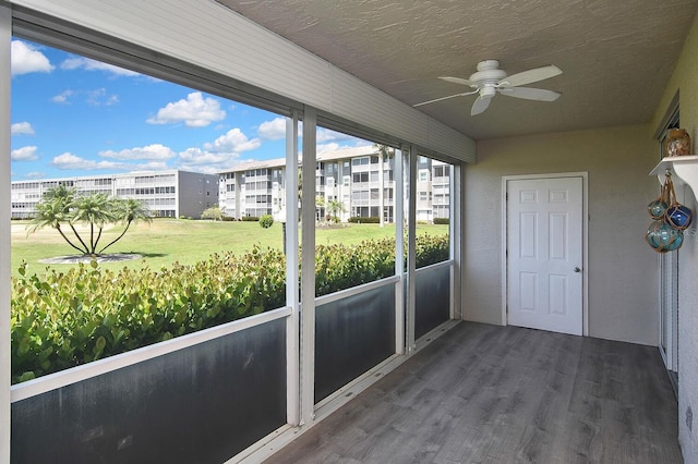 unfurnished sunroom with ceiling fan