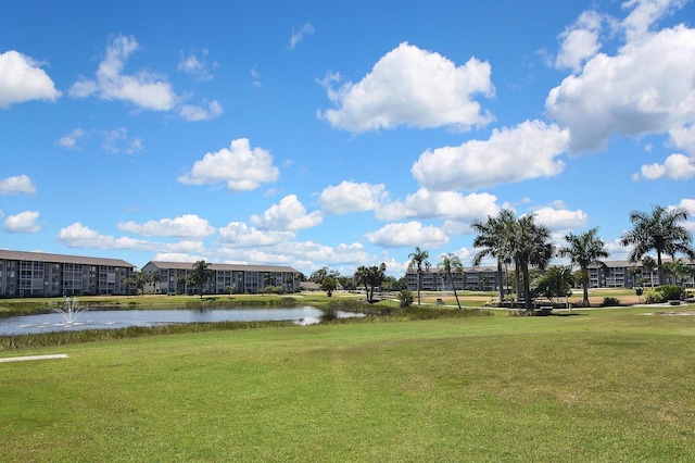 view of home's community with a water view and a lawn