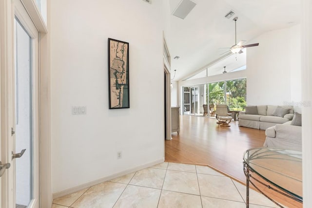 living room featuring ceiling fan, lofted ceiling, and light tile patterned flooring