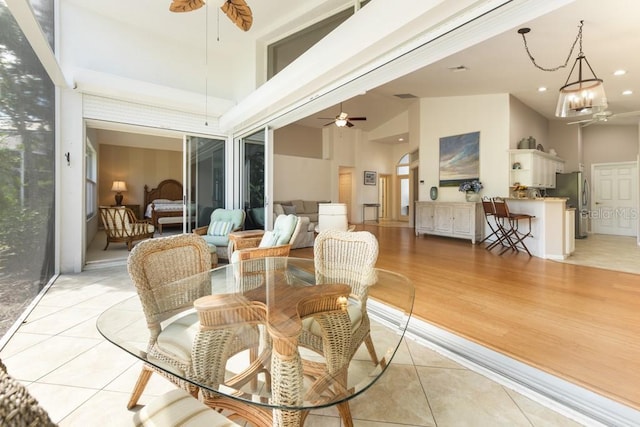 sunroom / solarium with vaulted ceiling and ceiling fan with notable chandelier