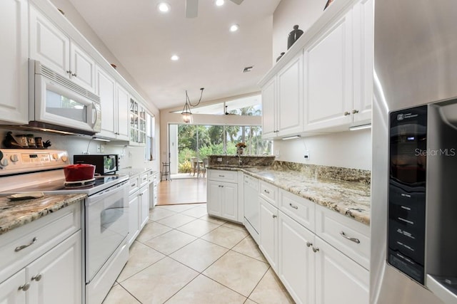 kitchen featuring white appliances, white cabinetry, and lofted ceiling