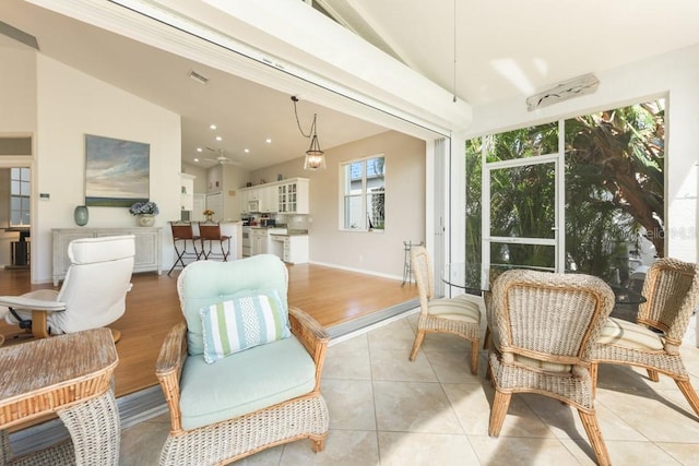 sunroom with ceiling fan and lofted ceiling