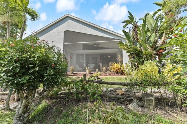 back of property featuring ceiling fan and a sunroom