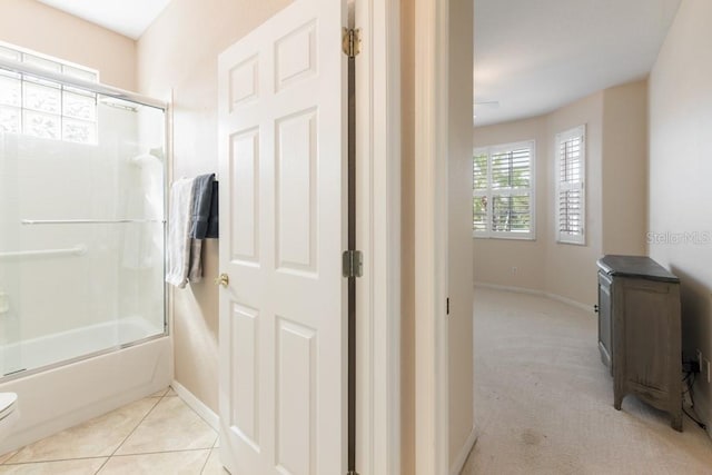 bathroom with tile patterned floors, toilet, and enclosed tub / shower combo