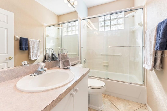 full bathroom with a wealth of natural light, tile patterned flooring, bath / shower combo with glass door, and toilet