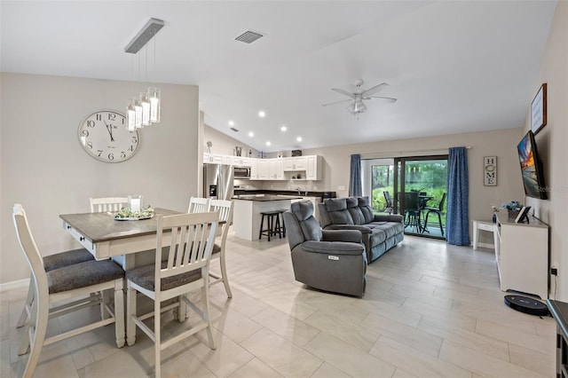 dining area with ceiling fan with notable chandelier and lofted ceiling