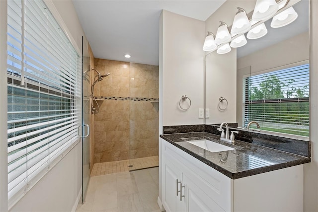 bathroom featuring a chandelier, vanity, a shower with shower door, and tile patterned flooring