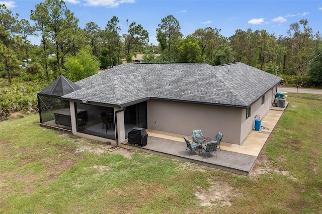 back of house with glass enclosure, a patio area, and a yard