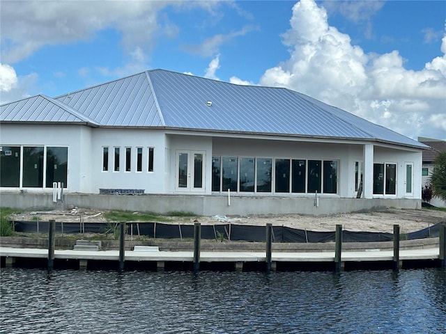 back of property featuring french doors and a water view