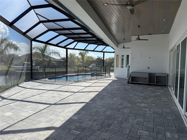 view of swimming pool featuring a patio, ceiling fan, and glass enclosure