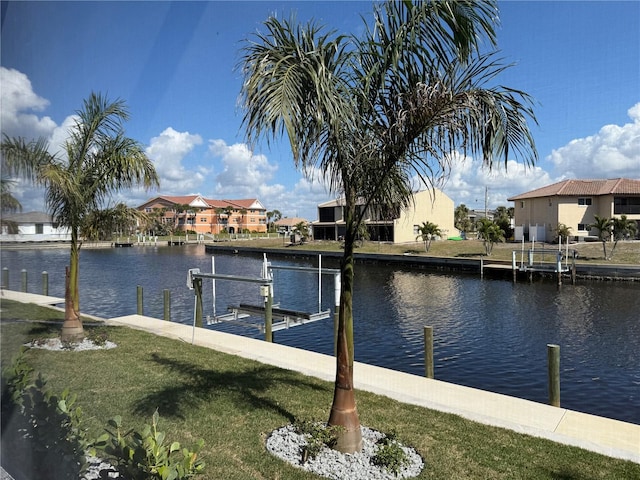 dock area featuring a water view and a lawn