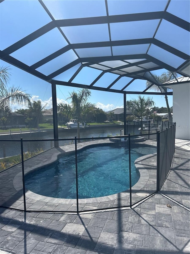 view of swimming pool with a lanai, a patio area, and a water view