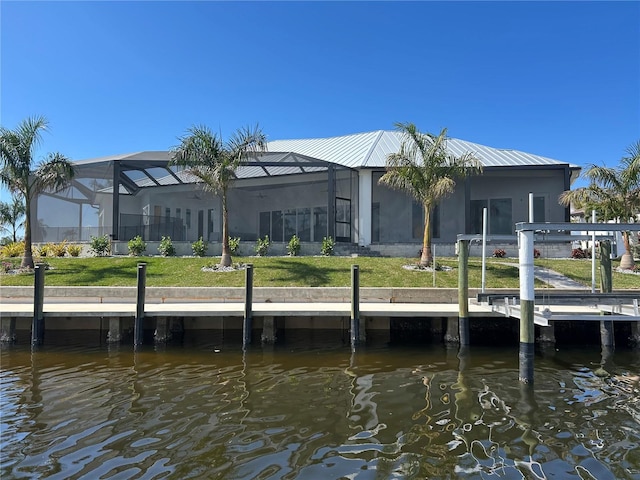 dock area with a water view, a yard, and a lanai