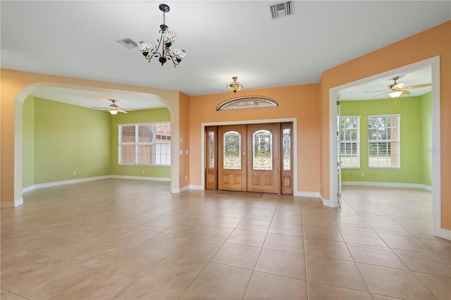 entrance foyer with light tile patterned floors and ceiling fan with notable chandelier