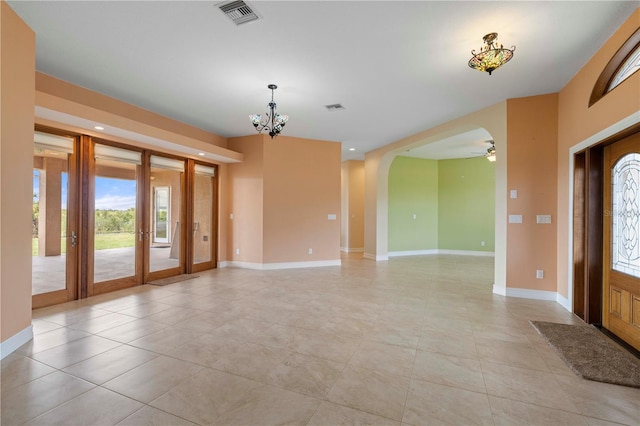 tiled foyer featuring french doors and ceiling fan with notable chandelier