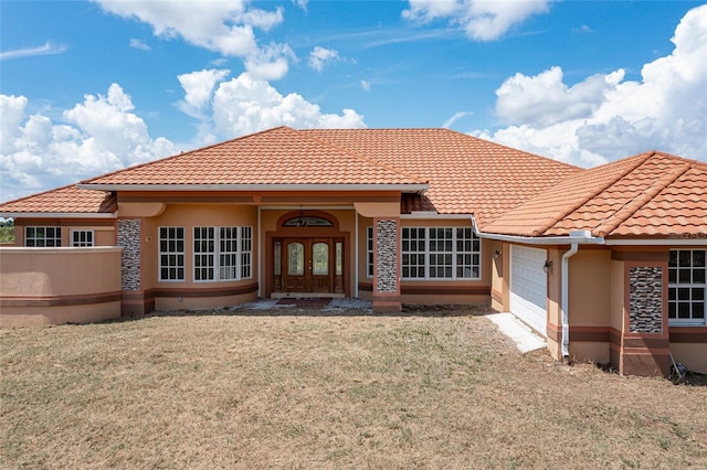 rear view of property with french doors and a garage