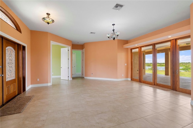 entrance foyer featuring french doors, light tile patterned floors, and a chandelier