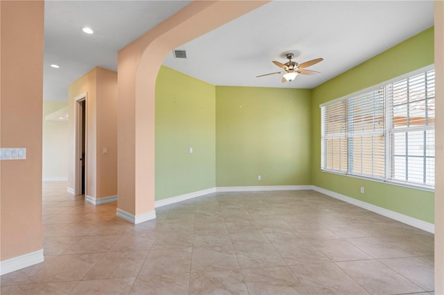 tiled empty room featuring ceiling fan