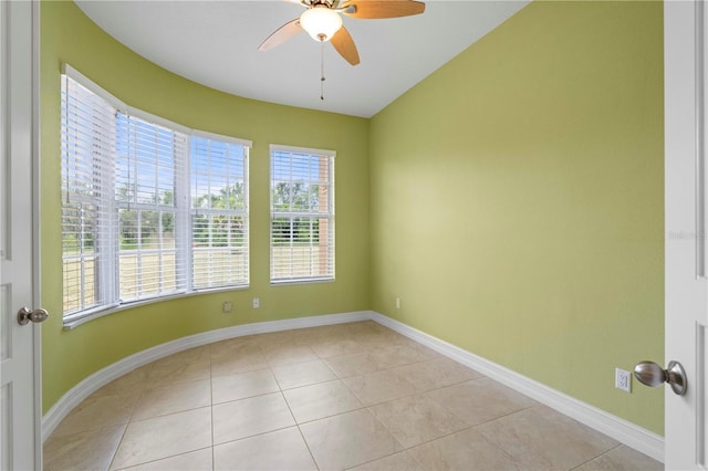 empty room featuring ceiling fan, plenty of natural light, and light tile patterned floors