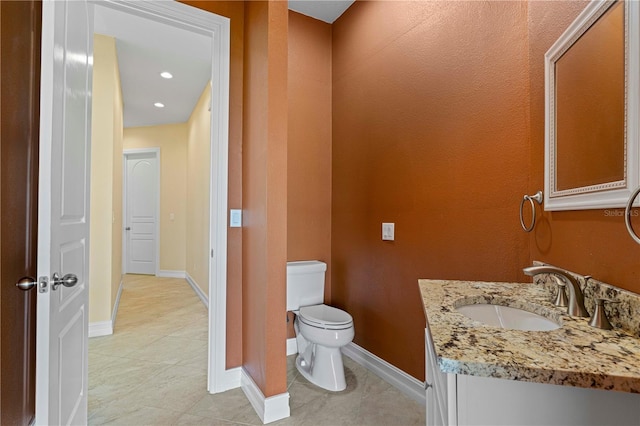 bathroom with tile patterned flooring, vanity, and toilet