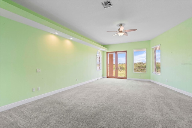 spare room with ceiling fan and light colored carpet