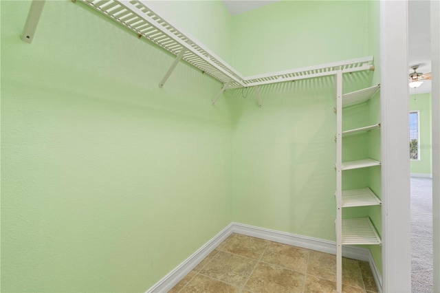 walk in closet with ceiling fan