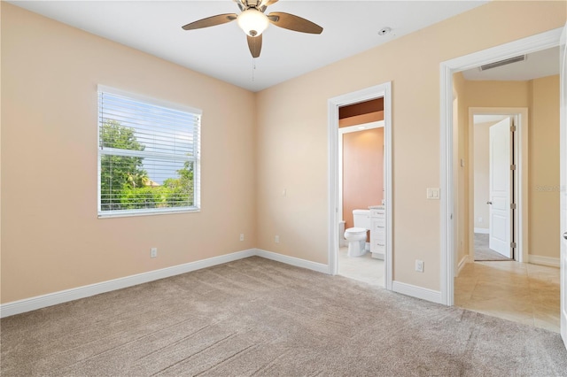 unfurnished bedroom with connected bathroom, light carpet, and ceiling fan