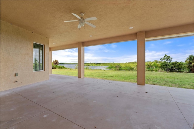 view of patio with ceiling fan and a water view