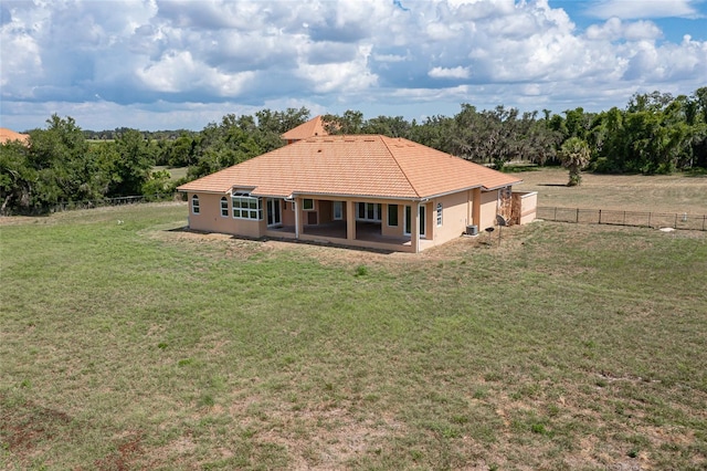 rear view of house featuring a yard, a patio, and a rural view