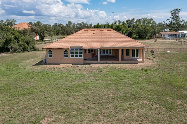 back of property with a yard and a patio