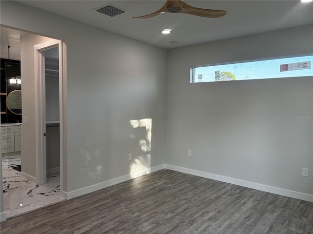 empty room with hardwood / wood-style floors and ceiling fan