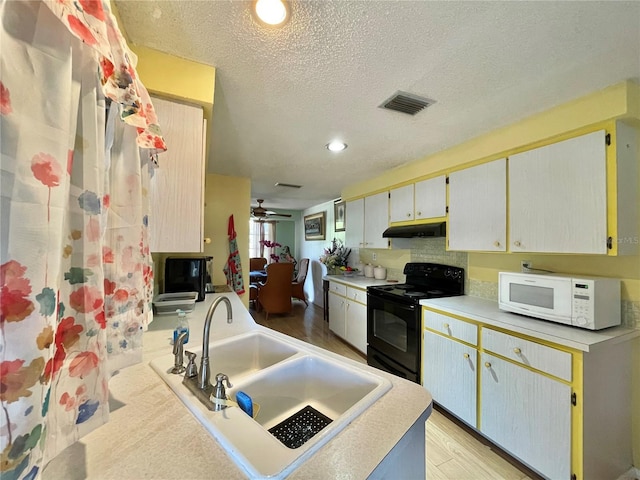 kitchen featuring sink, light hardwood / wood-style flooring, ceiling fan, a textured ceiling, and black / electric stove