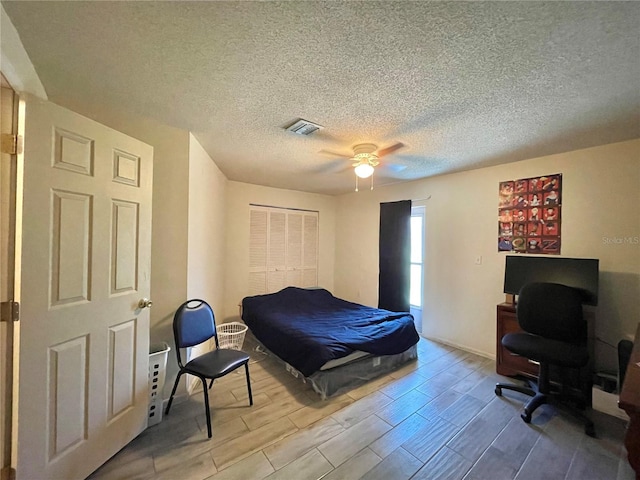 bedroom with ceiling fan, a closet, a textured ceiling, and hardwood / wood-style flooring