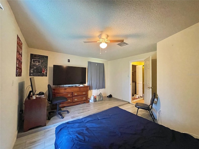 bedroom featuring light hardwood / wood-style floors, a textured ceiling, and ceiling fan