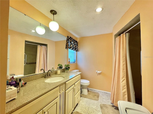 bathroom with tile floors, a textured ceiling, oversized vanity, and toilet