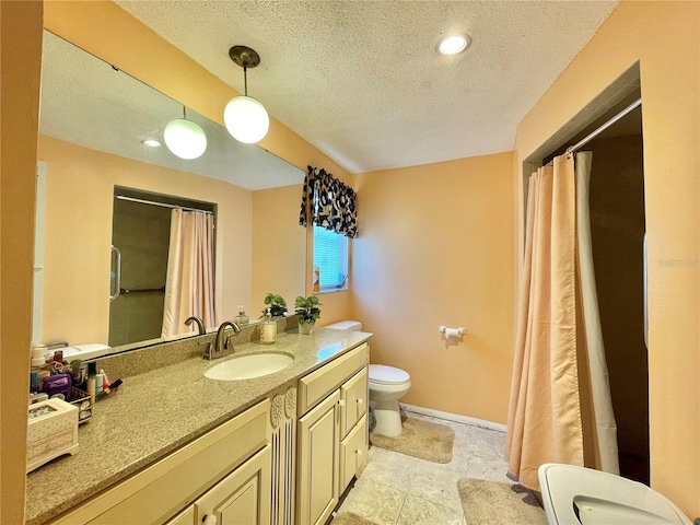 bathroom featuring vanity, a textured ceiling, and toilet