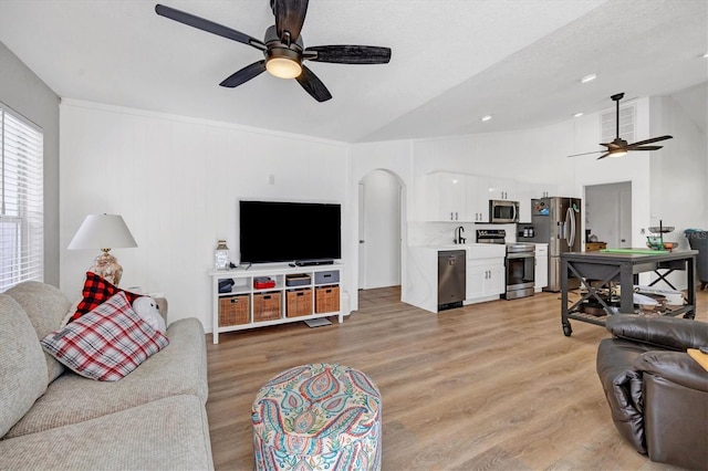 living room featuring vaulted ceiling, ceiling fan, and light hardwood / wood-style floors