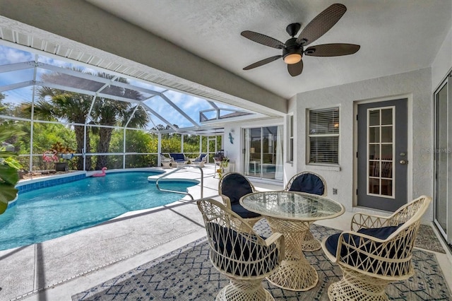 view of pool with ceiling fan, a patio, and glass enclosure